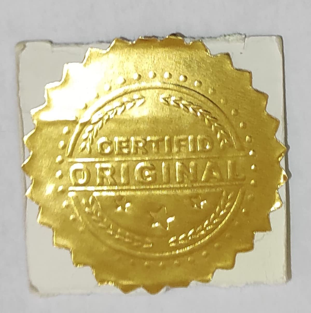 A gold circular cover sticker with the word “Original” stamped on it