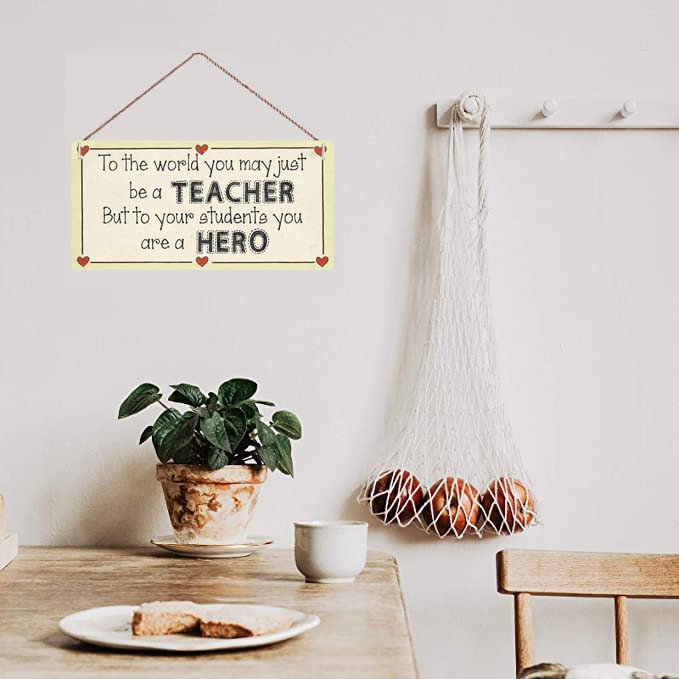 A hanging sign printed on wood with a beautiful phrase for teachers