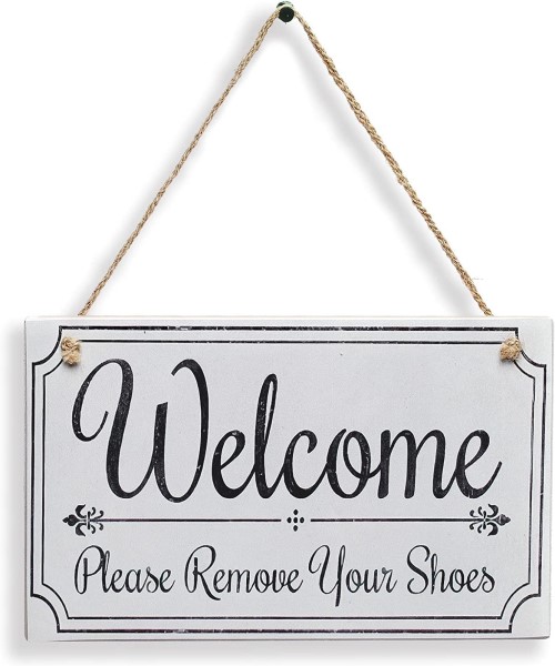 ”Decorative wooden sign printed with the phrase “Welcome, please remove your shoes